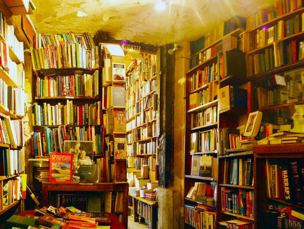 Crowded shelves of used books in a small bookshop